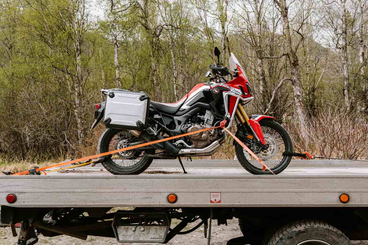 Motorcycle secured with straps on a flatbed tow truck