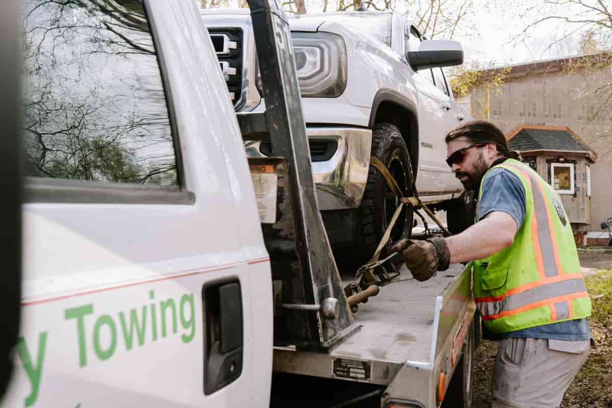 Tow operator securing a vehicle on a light-duty flatbed