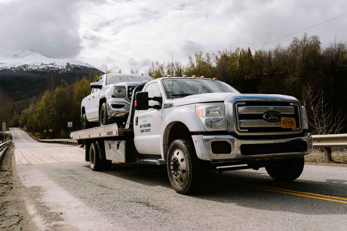 Pickup truck transported on a light-duty flatbed along an Alaska highway