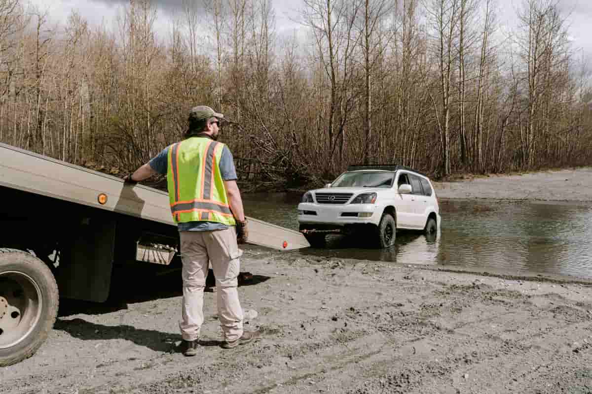 Tow operator preparing winching equipment beside an accessible road